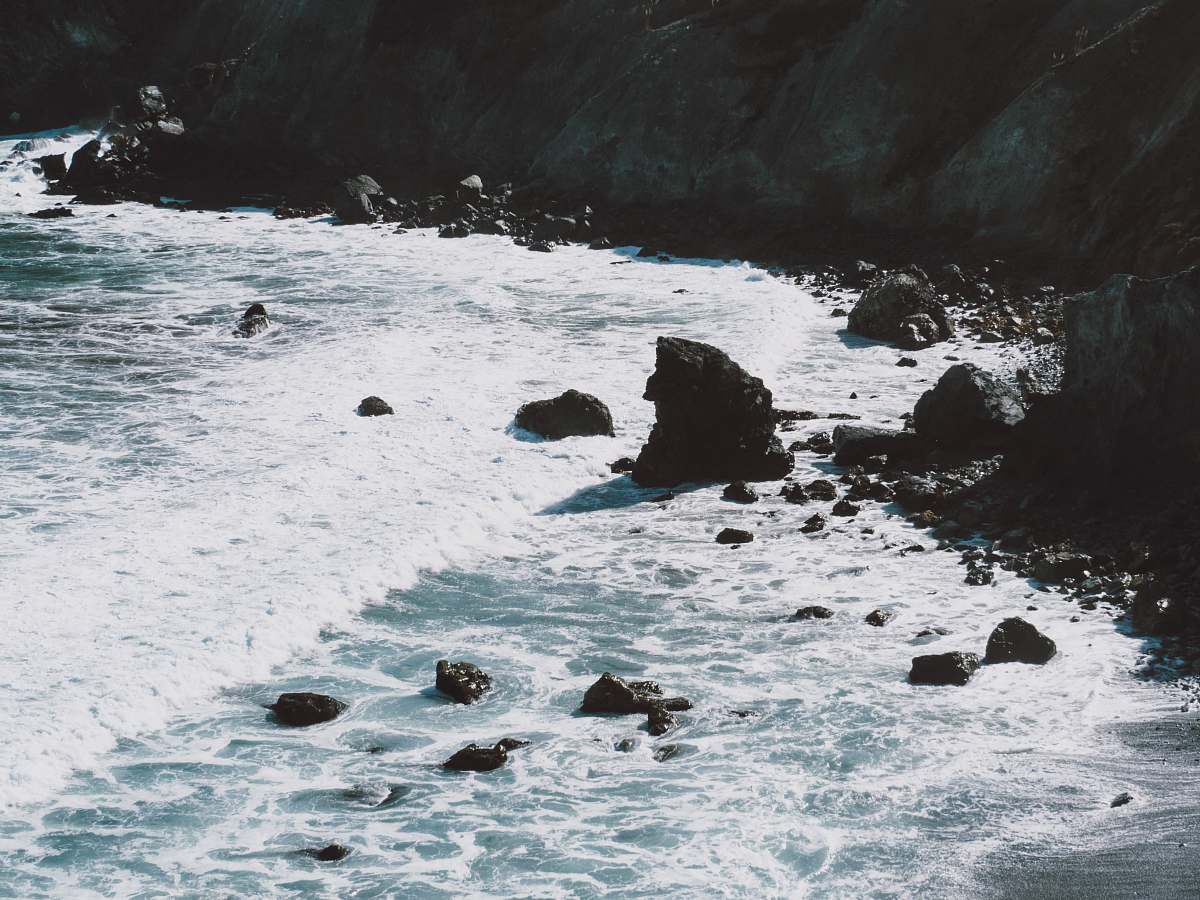 big sur brown rock formation and body of water at daytime coast